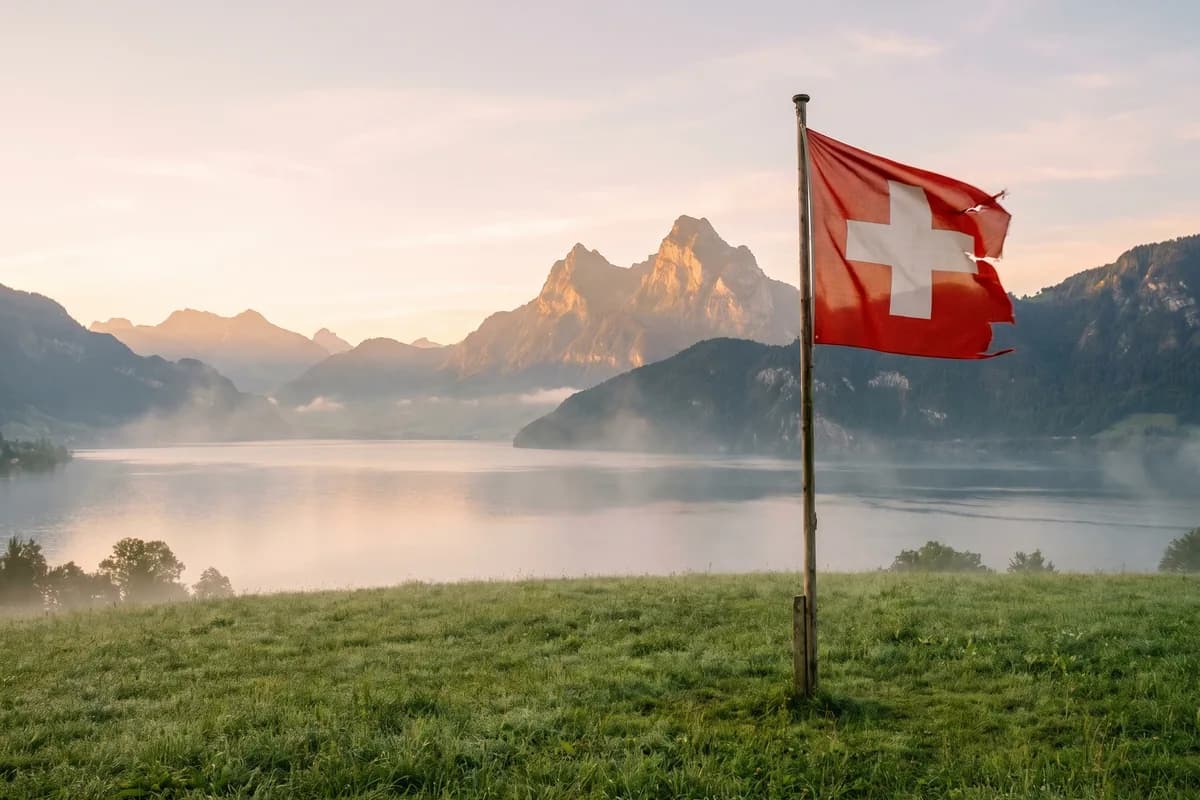 Die Rütliwiese über dem Vierwaldstättersee im Morgenlicht mit Schweizer Fahne, sinnbildlicher Gründungsort der Eidgenossenschaft 1291